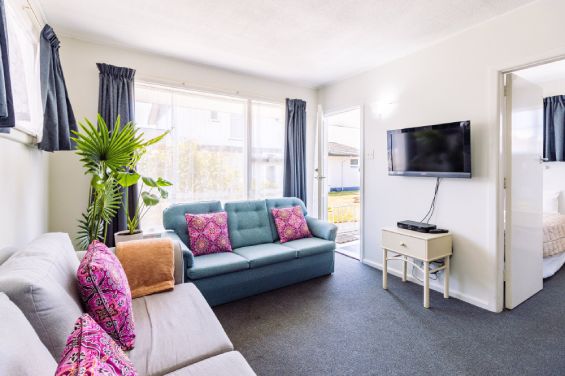 Spacious lounge area with sofas and TV in the Two-Bedroom Garden unit at Belle Bonne Motel Christchurch