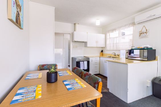 Dining table and full kitchen in the Two-Bedroom Garden unit at Belle Bonne Motel Christchurch
