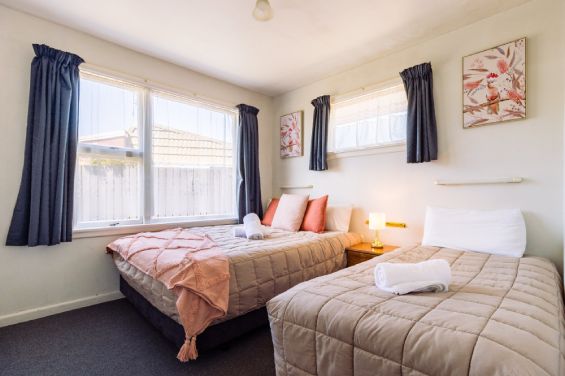 Main bedroom with a queen-size and a single bed in the Two-Bedroom Garden unit at Belle Bonne Motel Christchurch