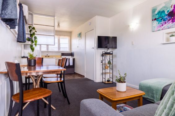 Open-plan living area with private balcony access in the Large Apartment at Belle Bonne Motel Christchurch