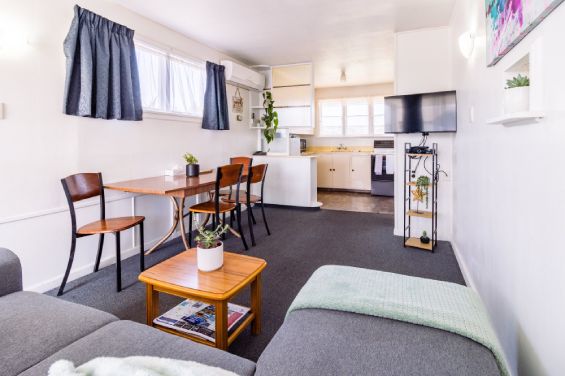 Lounge, dining table and TV in the Large Apartment at Belle Bonne Motel Christchurch