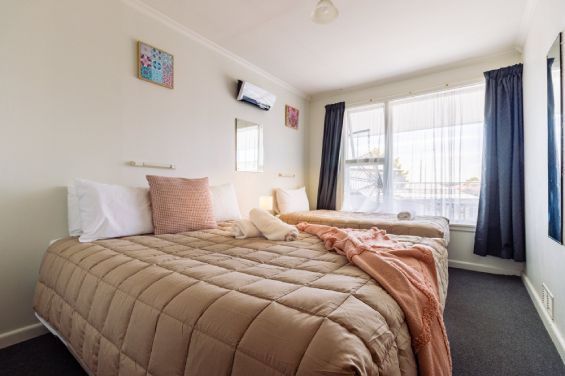 The main bedroom has a king-size bed and a single bed in the Large Two-Bedroom Apartment at Belle Bonne Motel Christchurch